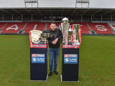 Michael Smith with the World Darts Championship trophy and Saints collection of silverware at The Totally Wicked Stadium