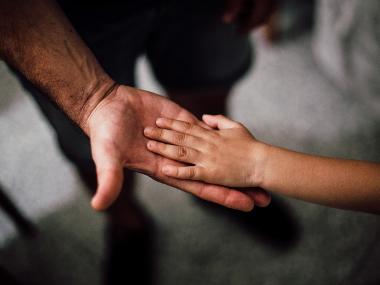 Child and adult holding hand